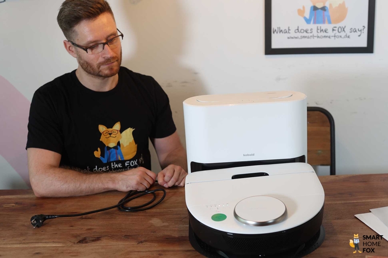 Die Absaugstation RB7 steht auf dem Tisch und ein Smart Home Fox Mitarbeiter betrachtet diese.